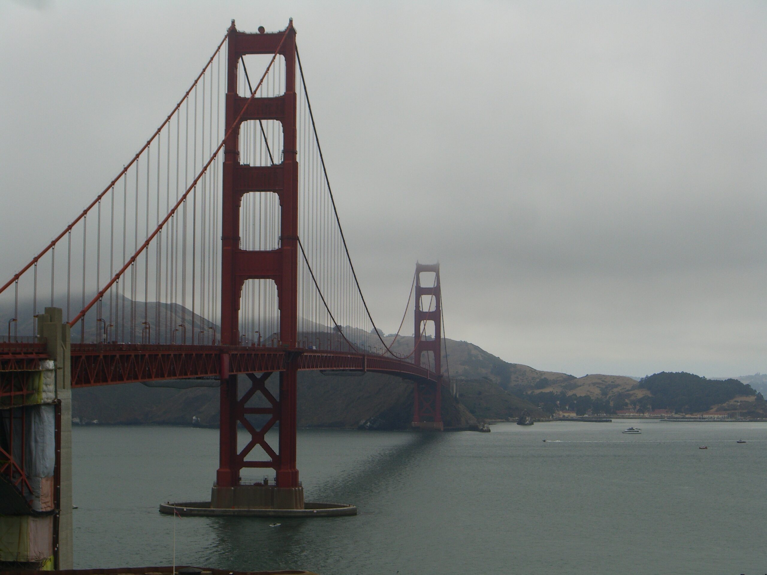 San Francisco's art deco Golden Gate Bridge appears through fog under overcast skies in 2006.