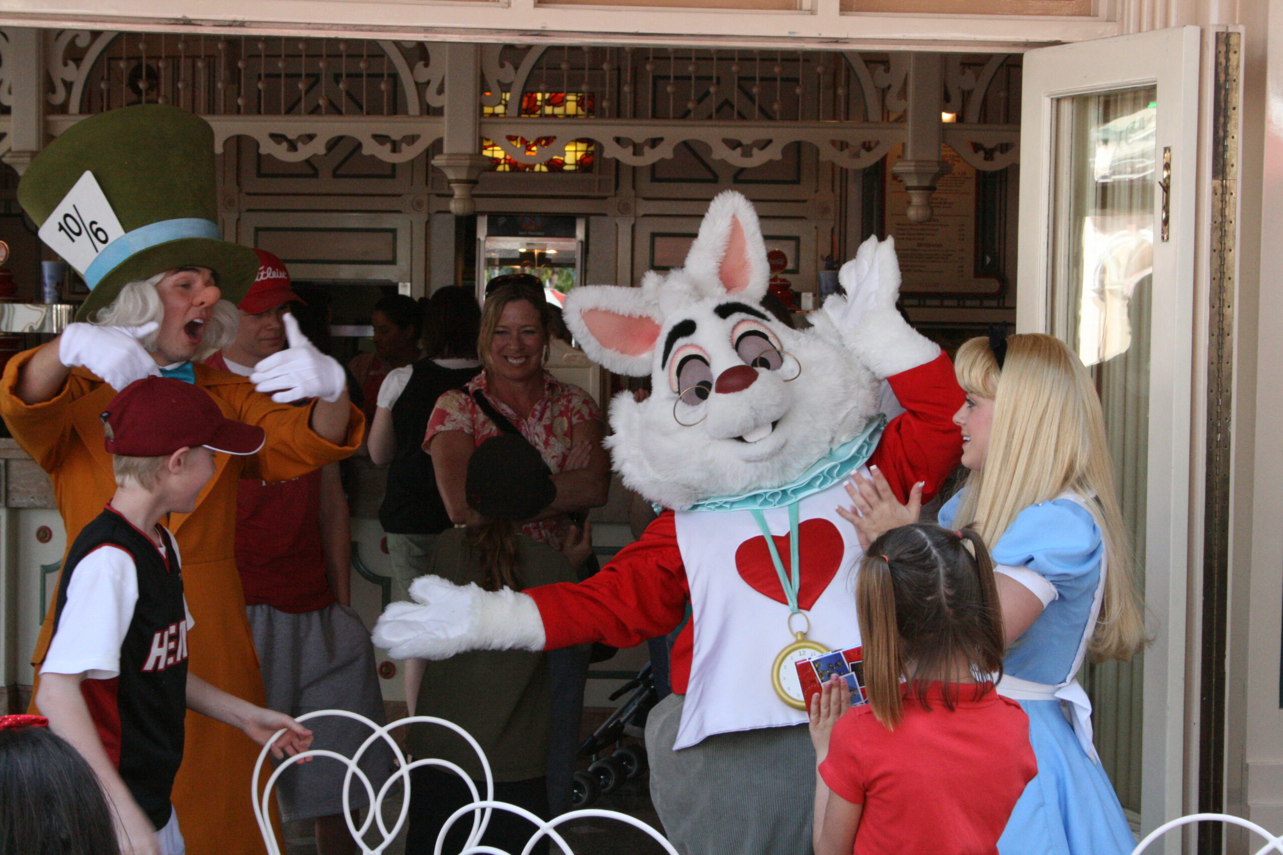 The Mad Hatter, White Rabbit, and Alice play Musical Chairs with children at Disneyland.