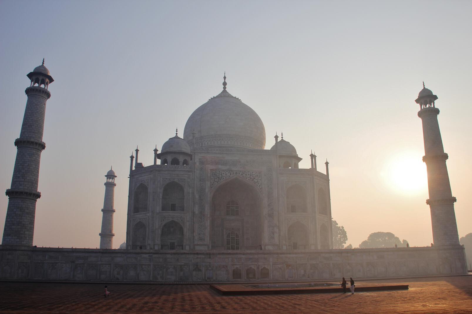 The sun rises behind the Taj Mahal.