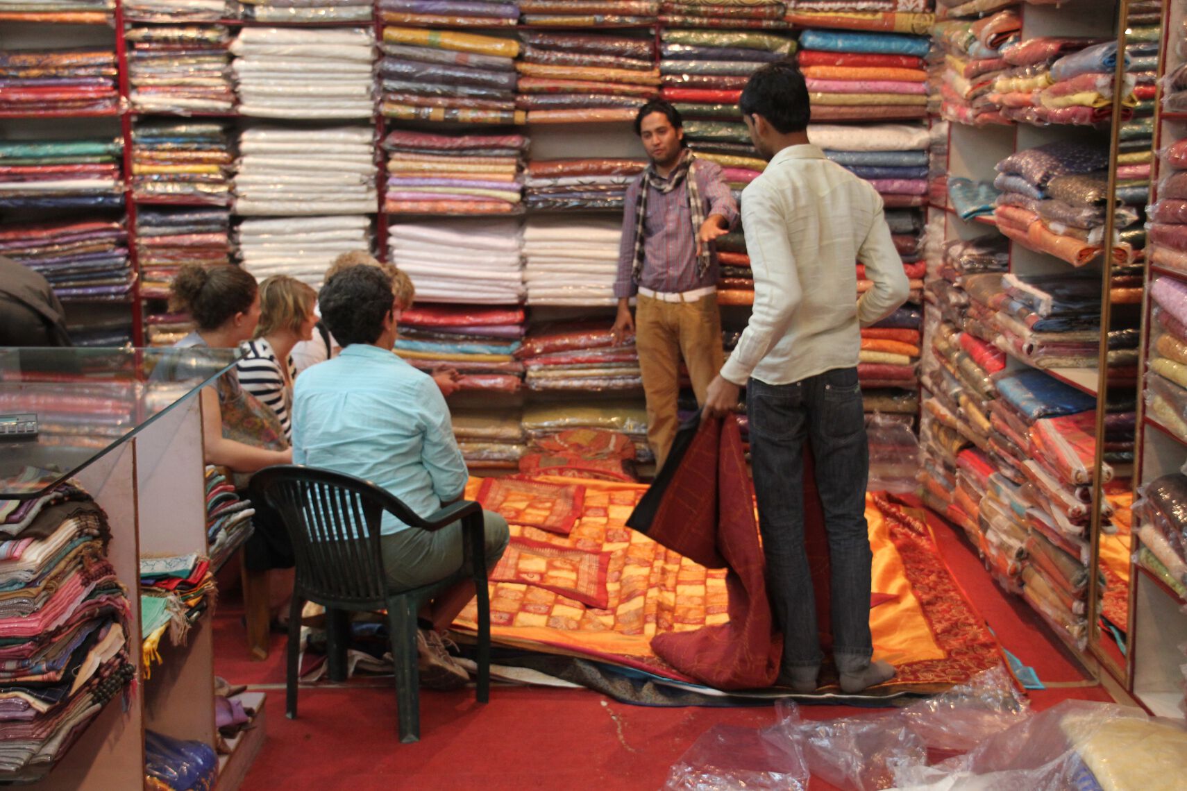 Tourists look at bed covers in a textiles shop in Jaipur, India.