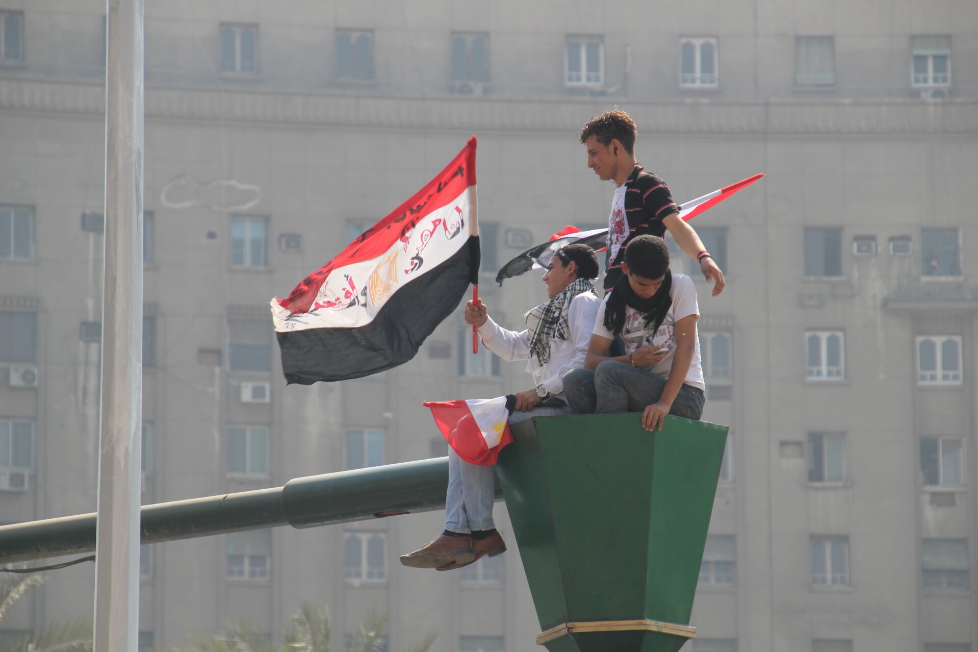 Teenagers wave a flag above Cairo's Tahrir Square on the day before a countrywide vote on constitutional amendments.