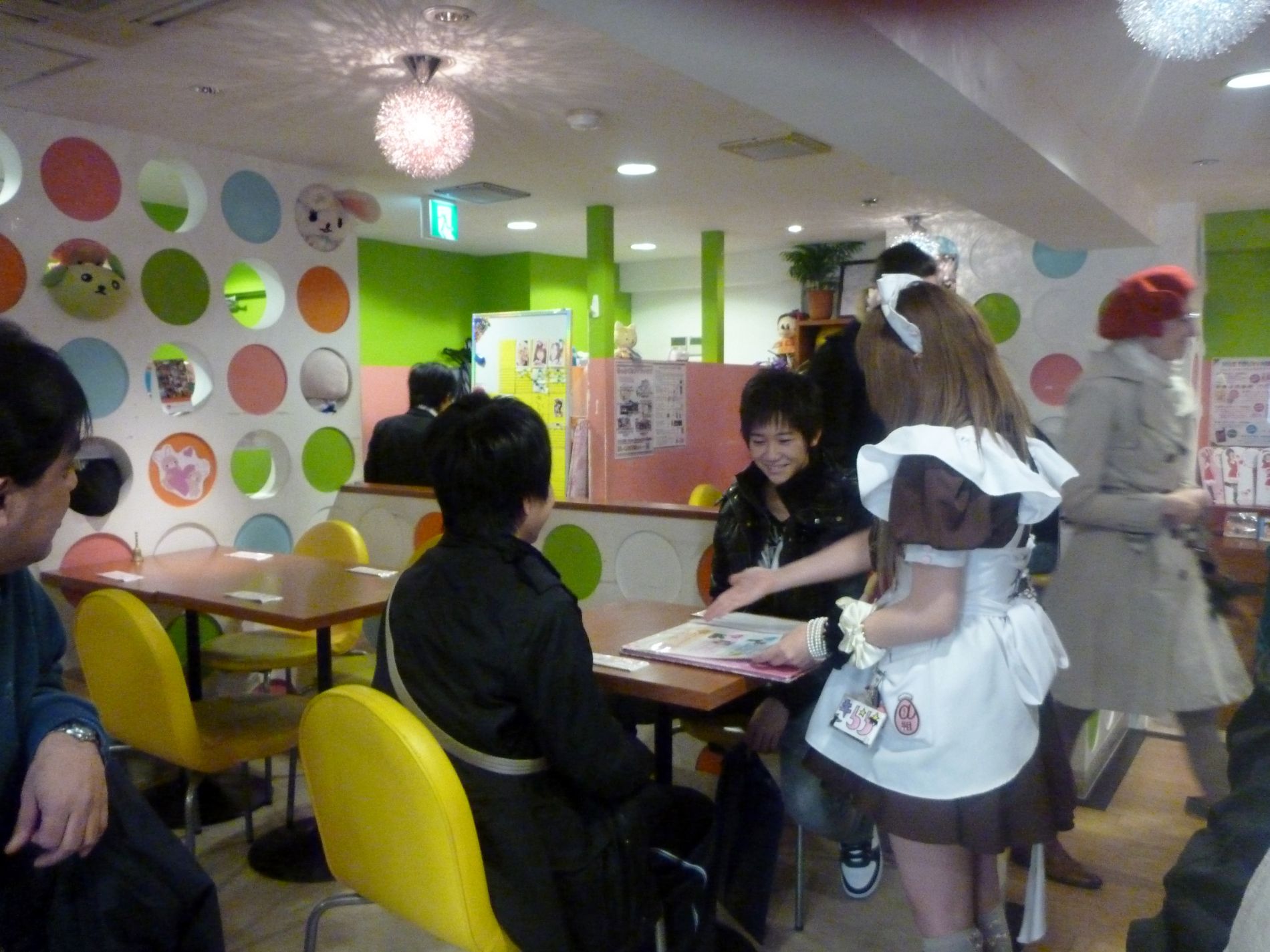 A Japanese girl dressed as a maid waits on boys in a maid cafe in Akihabara, Tokyo, Japan.