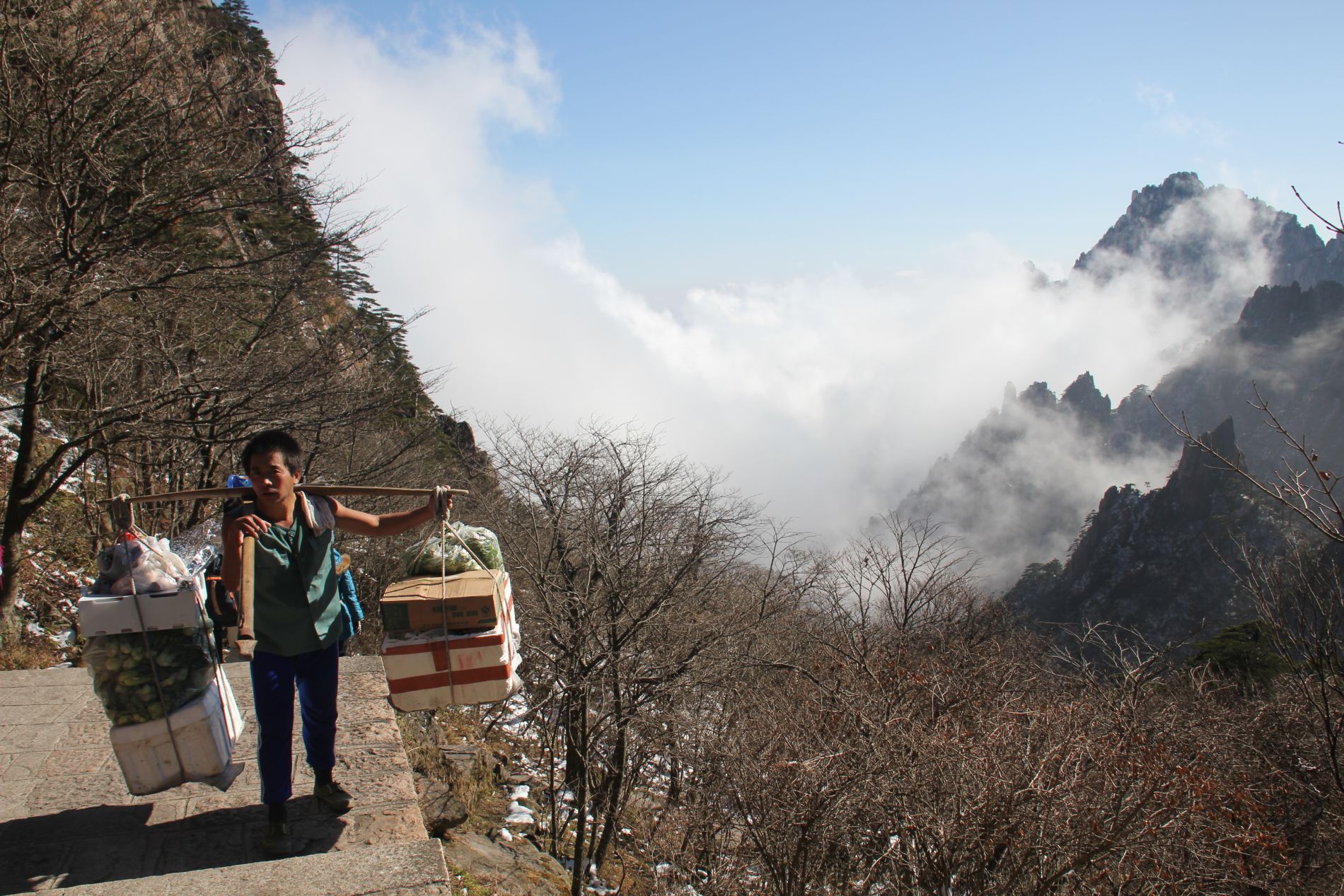 A porter carries food and supplies to hotels atop Huangshan.
