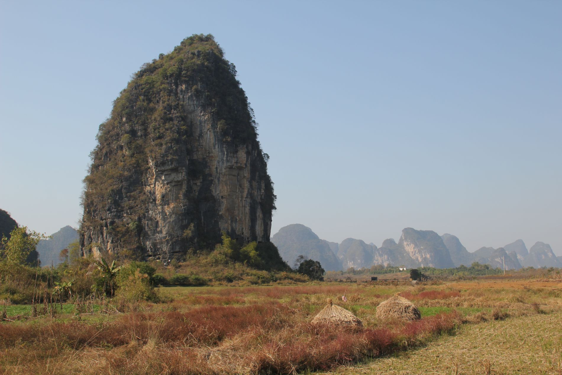 Climbers stand below The Egg, a karst in Y&aacute;ngshu&ograve;, GuÄ?ngxÄ«, China.