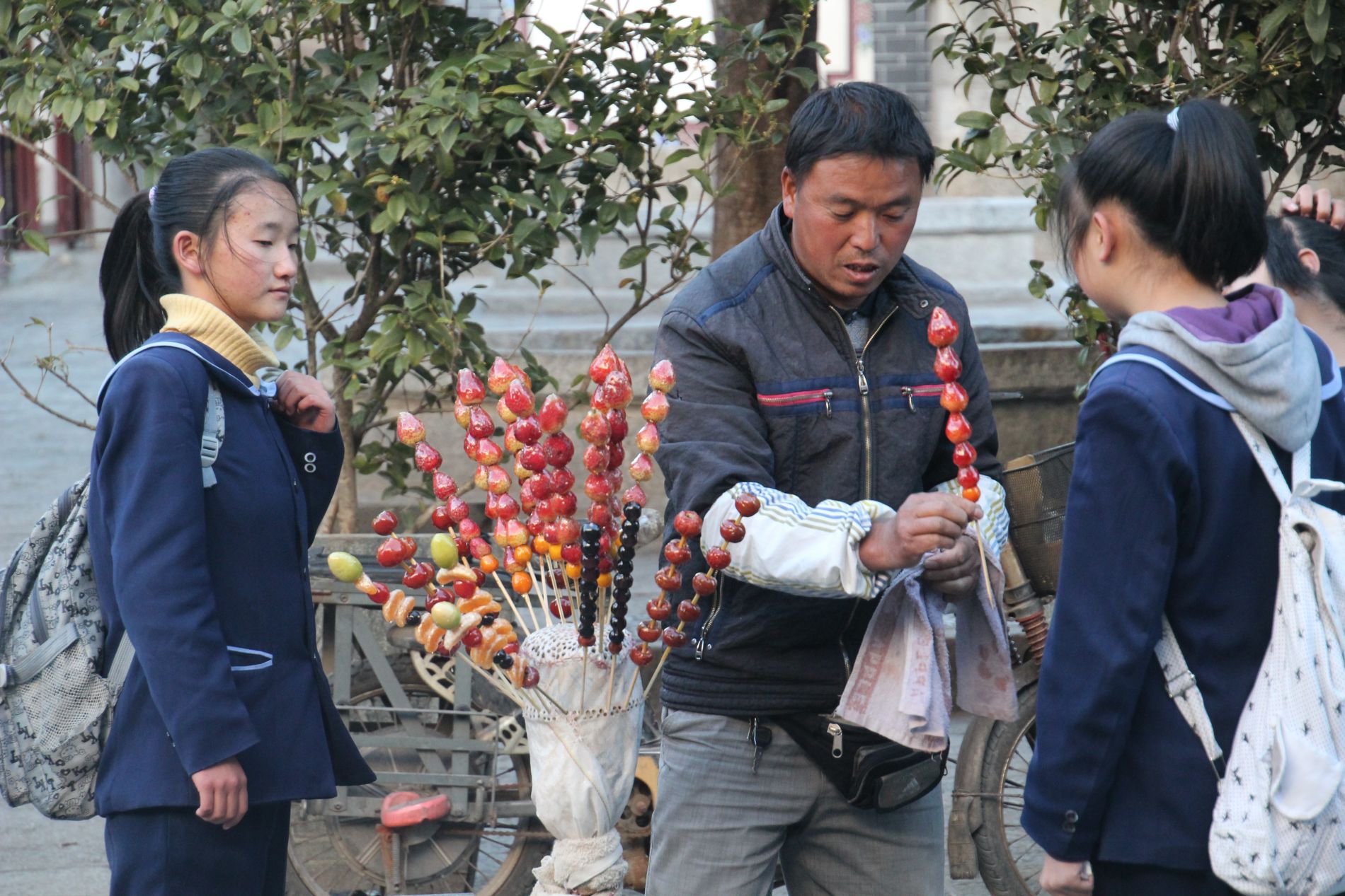 A man sells sugar-covered strawberries in D&agrave;lÇ?, China.