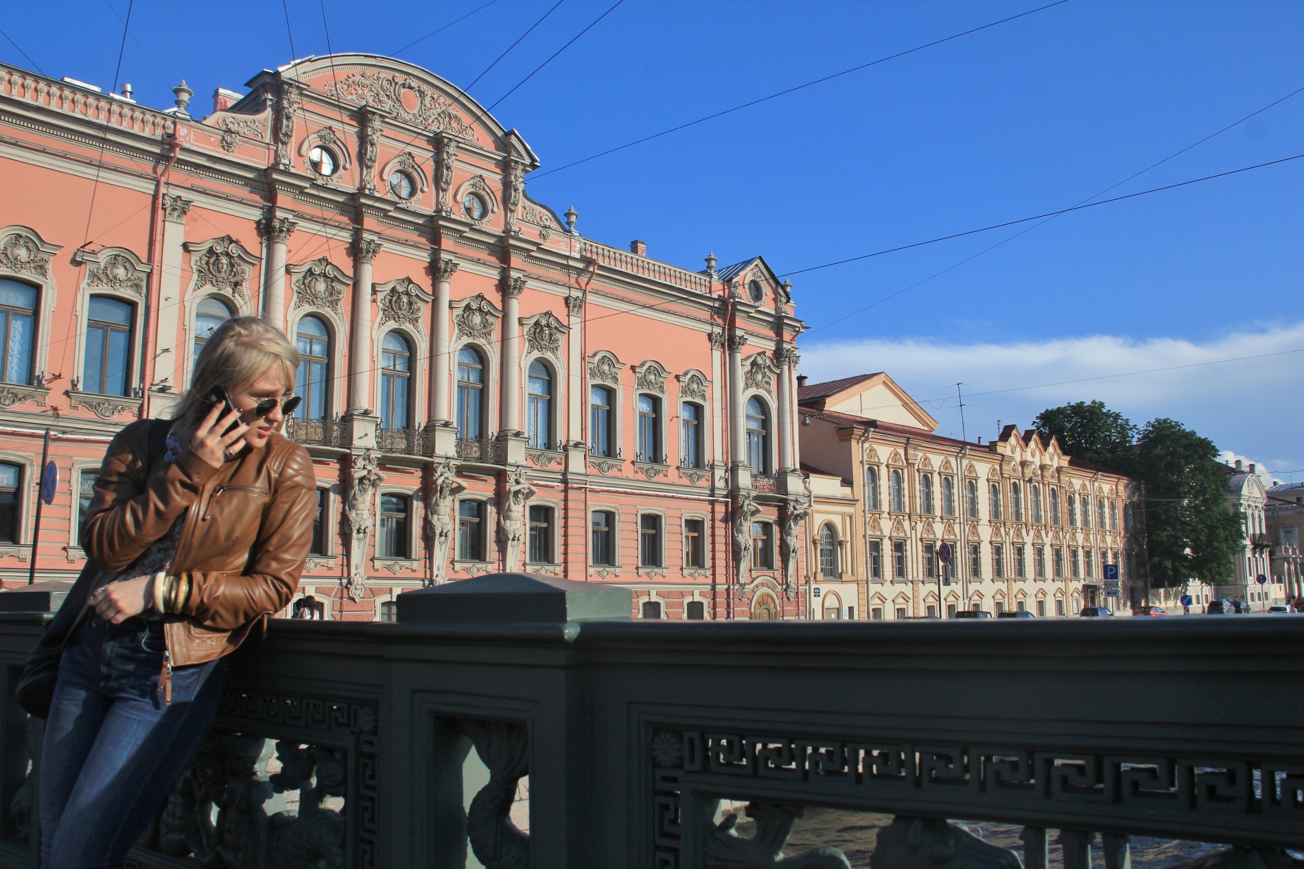 Nastya chats on a phone on Anichkov Bridge in St. Petersburg, Russia.