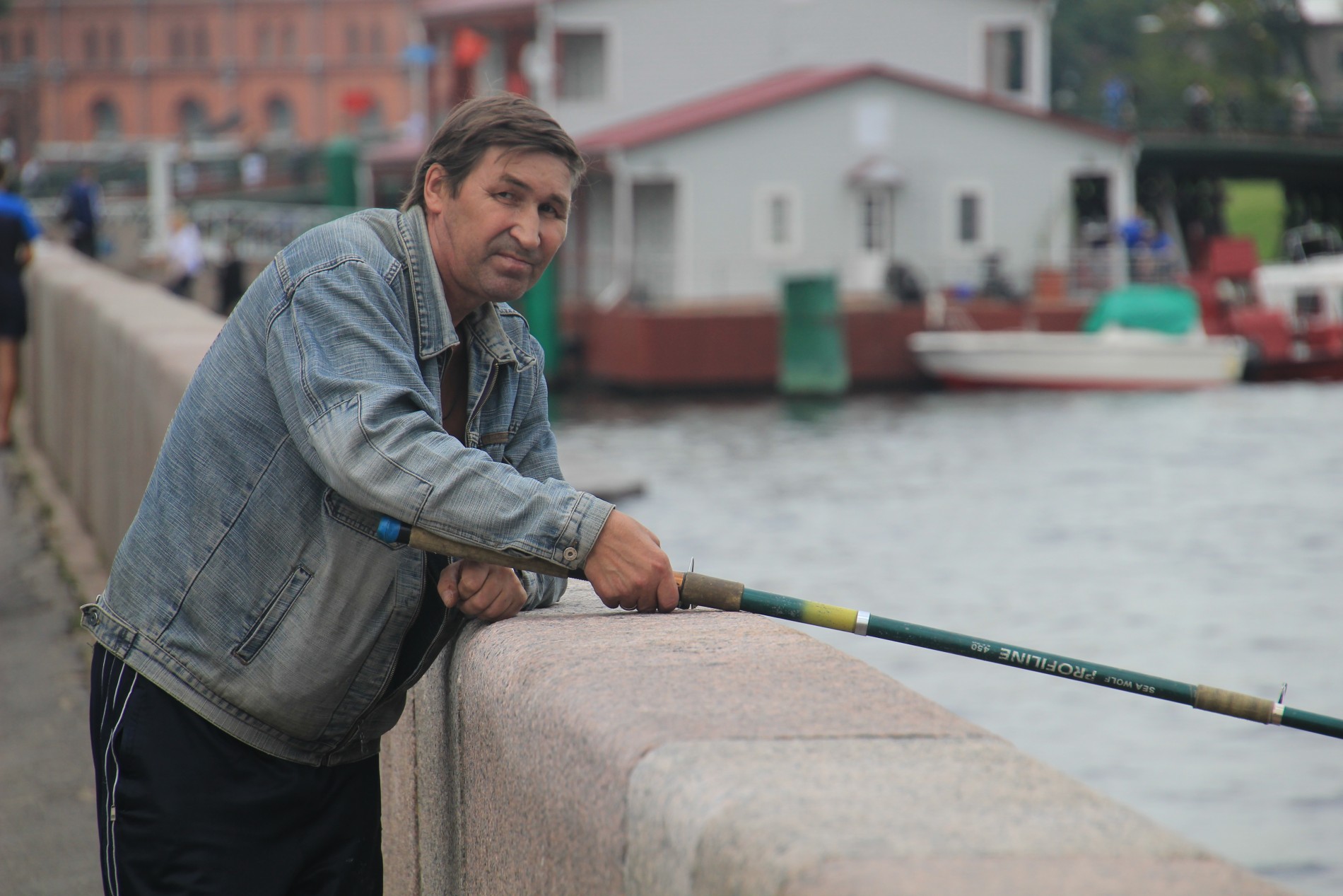 A Russian man fishes in a St. Petersburg river.