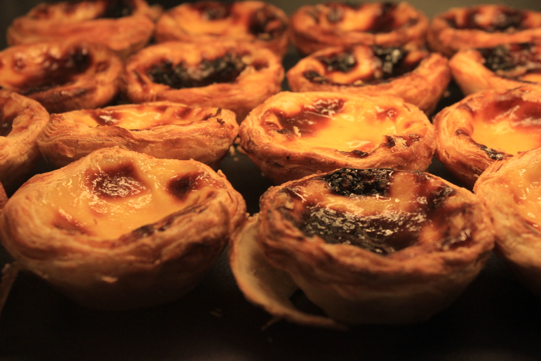 Past&eacute;is de Bel&eacute;m, Portugal's famous custard egg tart, sit on a rack waiting to be purchased.