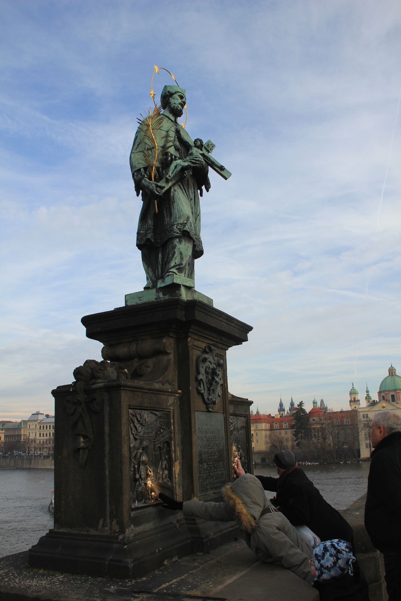 People touch, for good luck, the St. John of Nepomuk Statue on Prague's Charles Bridge.