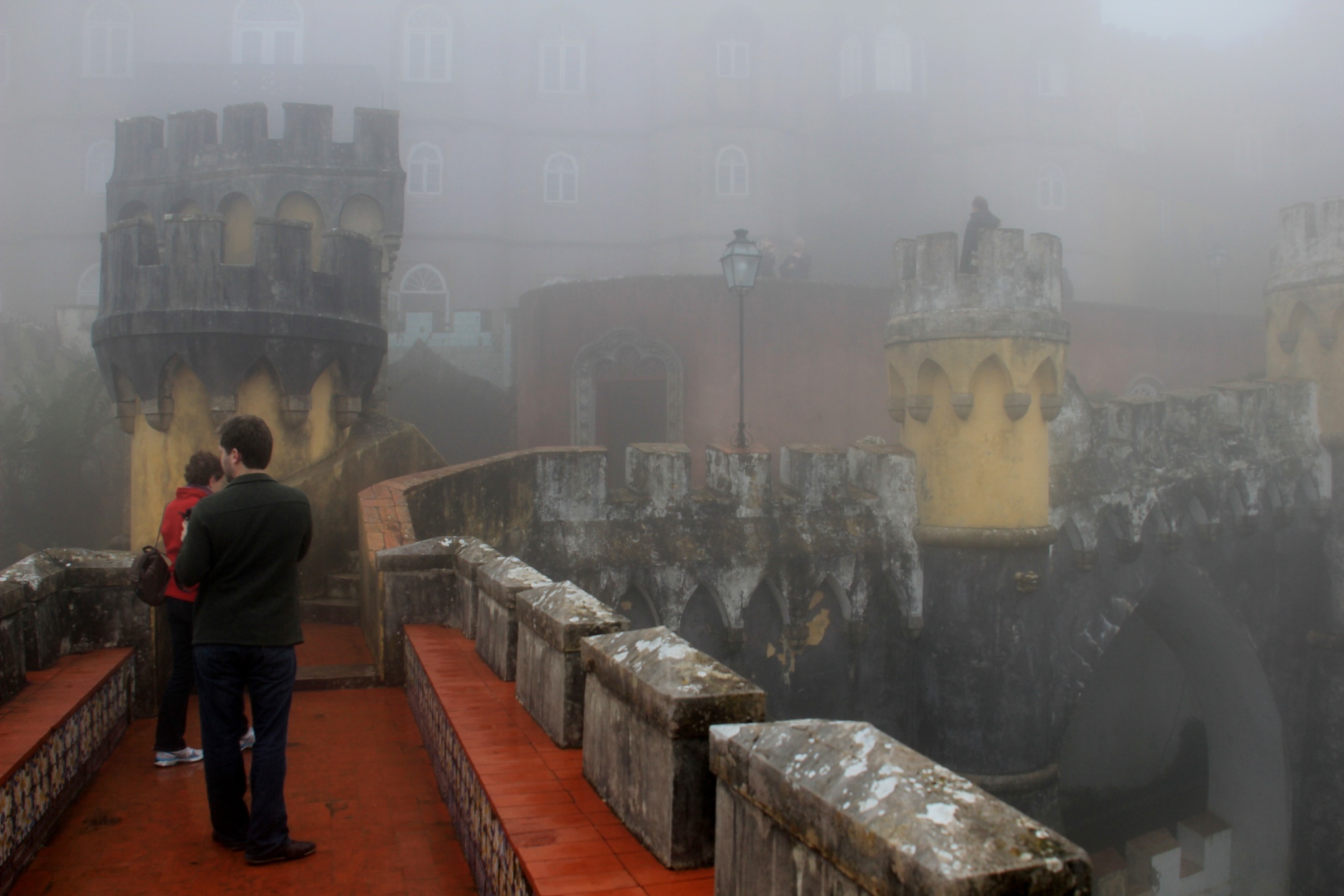 Tourists visit a fog-enveloped Pena National Palace in Sintra, Portugal.