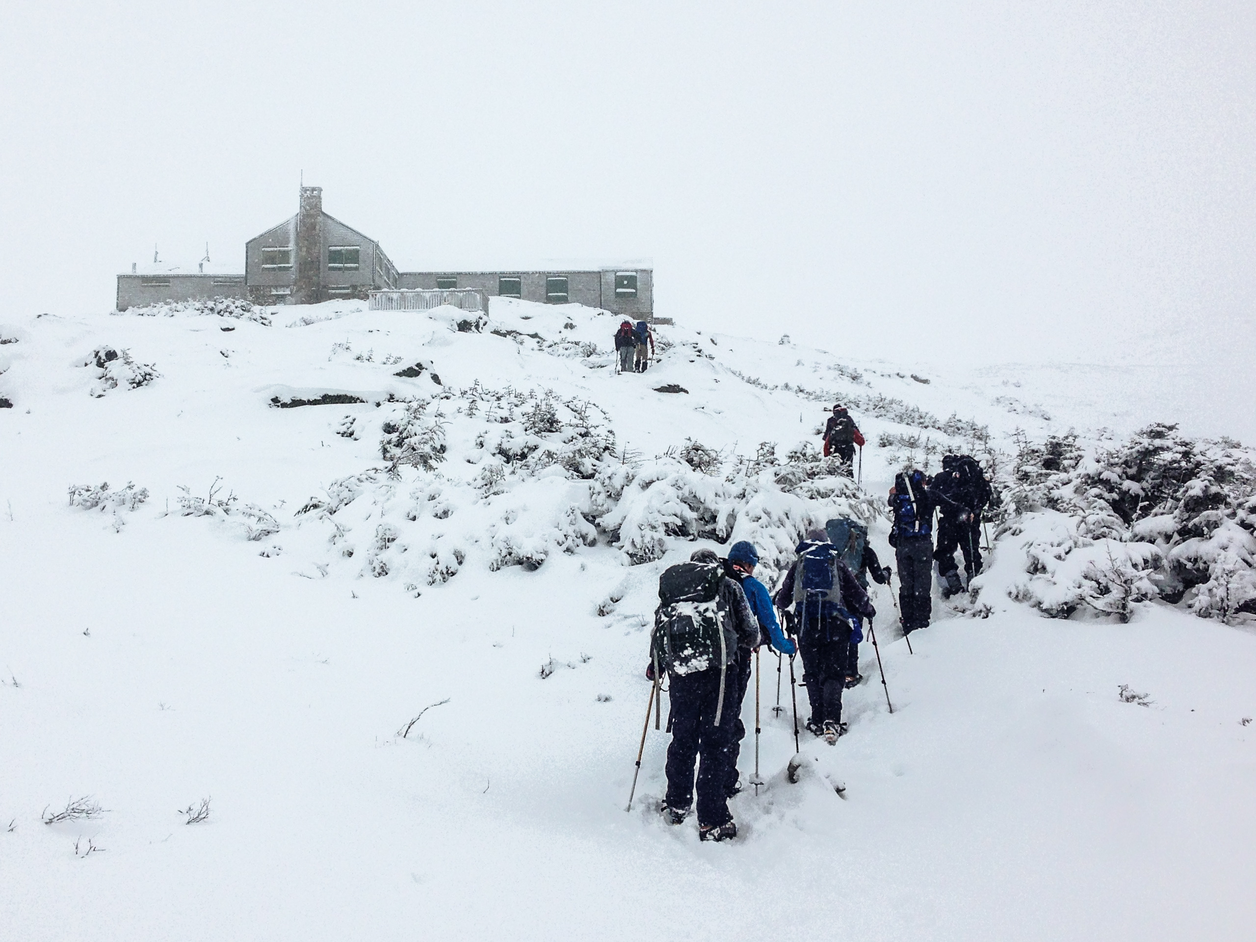 Hikers catch a glimpse of the Lake of the Clouds Hut below Mount Washington's summit.