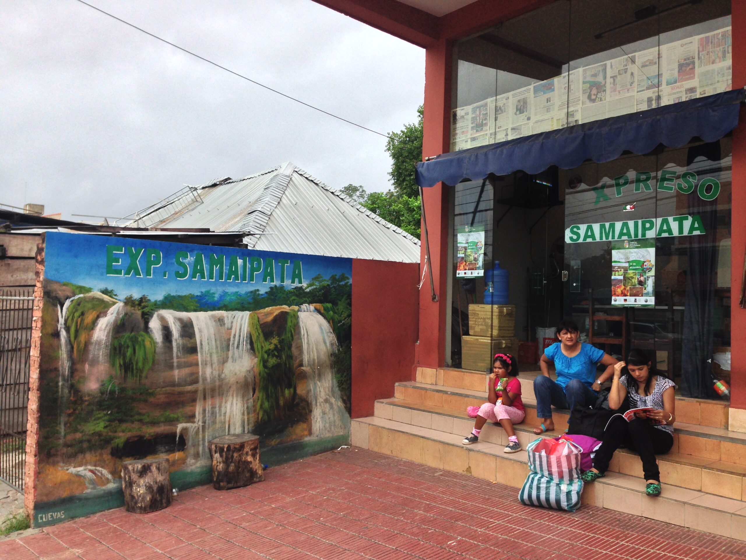A Bolivian family sits outside an office that organizes carpools to El Fuerte de Samaipata in Santa Cruz, Bolivia.