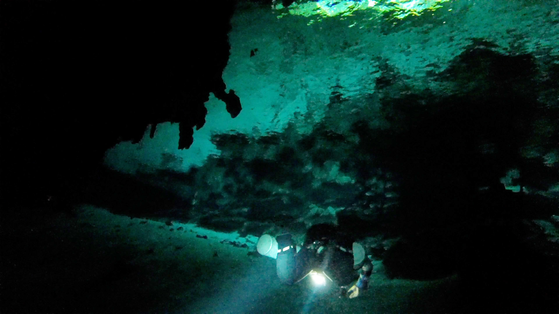 A diving guide dives in a cenote (limestone sinkhole) in the Dos Ojos cave system near Cancún, Mexico.