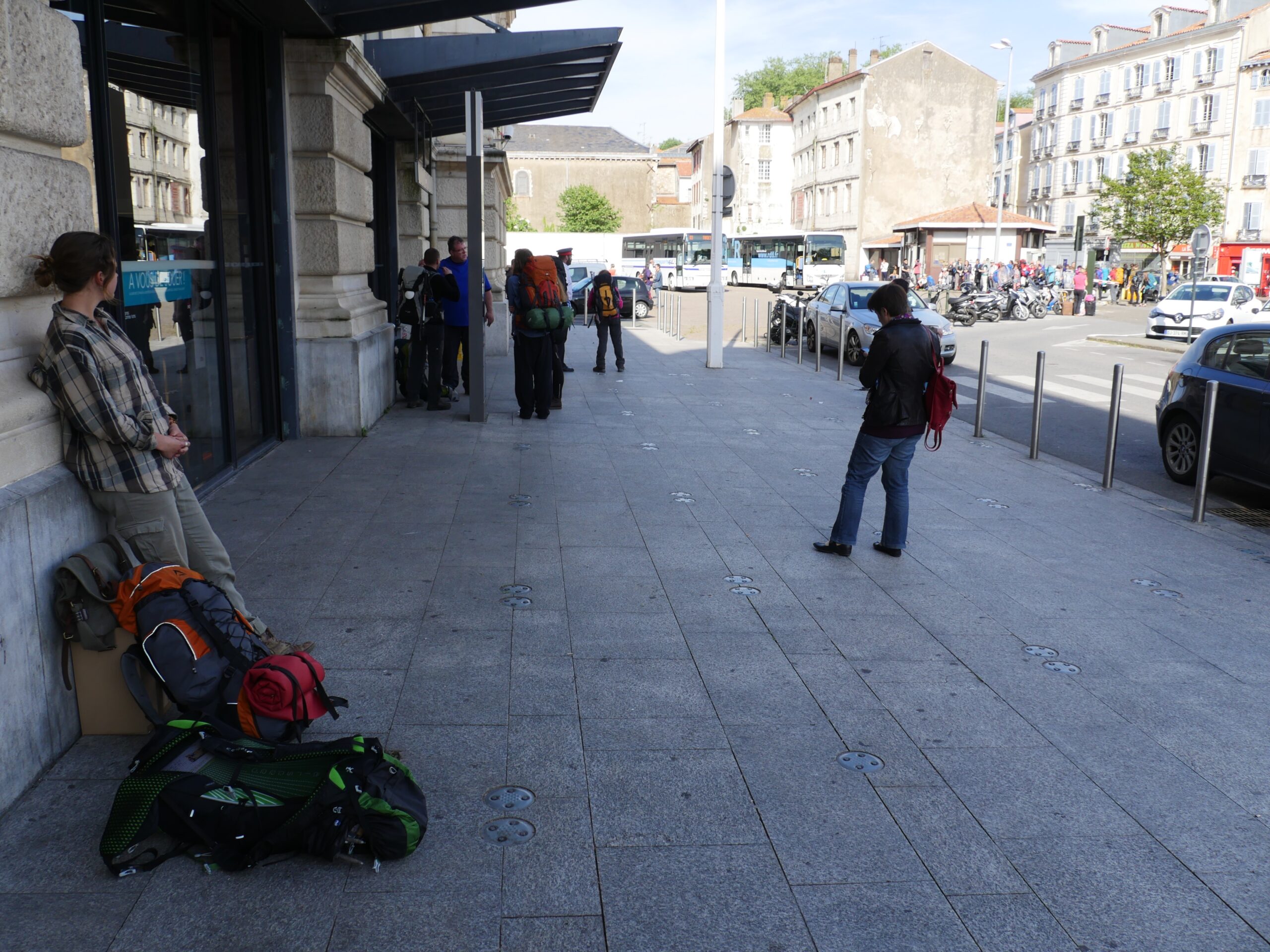 A young woman at the train station in Bayonne, France prepares to hike the Camino de Santiago while waiting for a bus to Saint-Jean-Pied-de-Port.