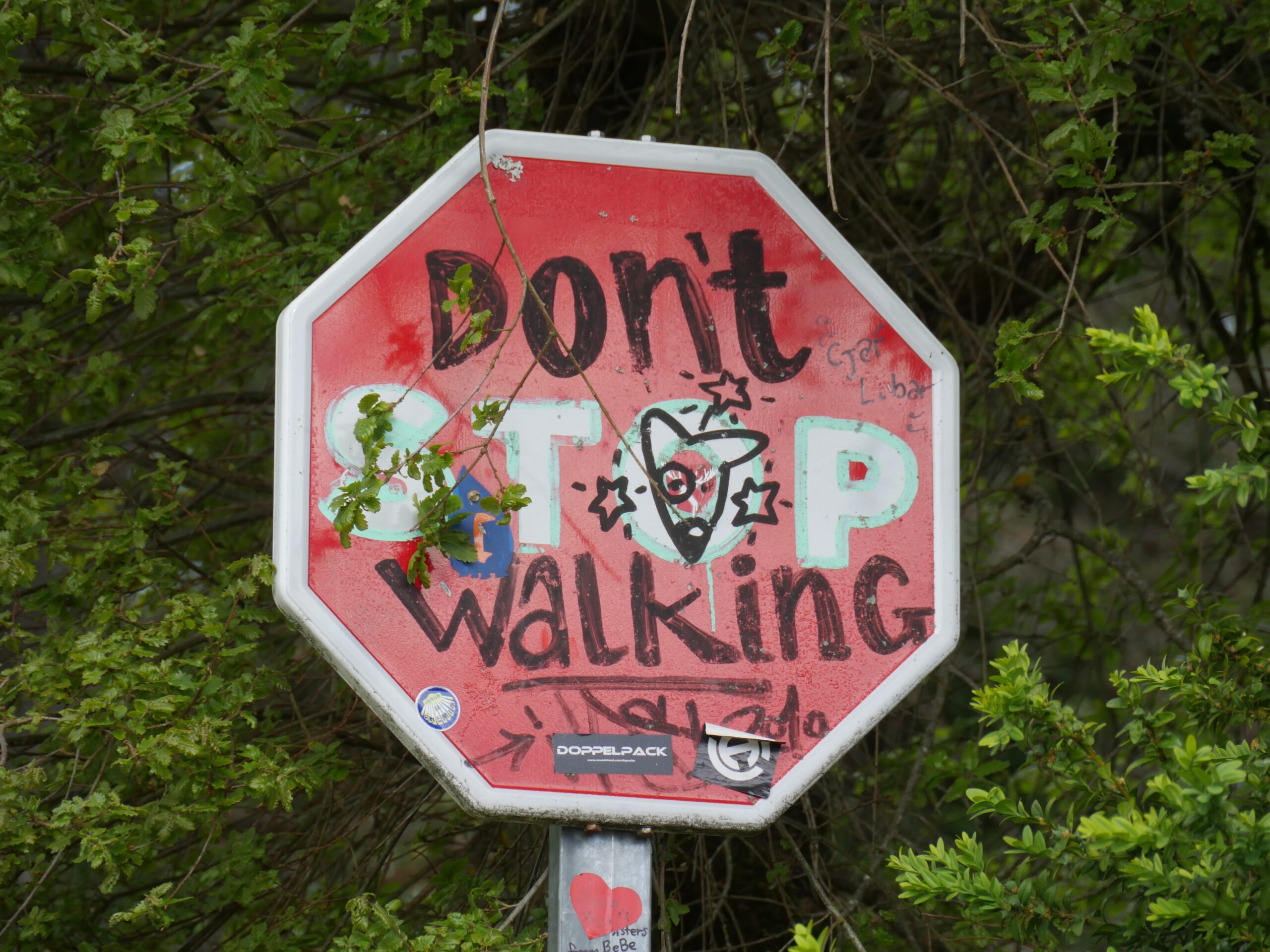 Stop sign graffiti in Spain encourages pilgrims walking the Camino de Santiago.