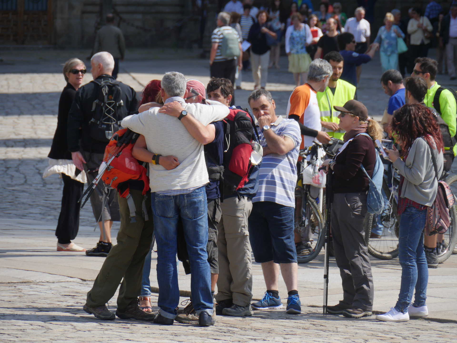 A group of friends hugs in the plaza in front of the Santiago de Compostela Cathedral.