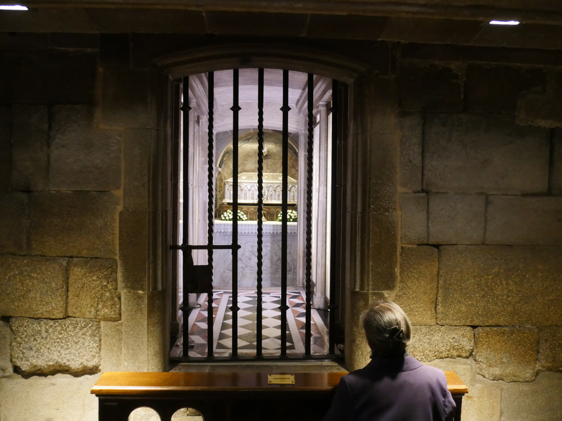 A woman prays in front of the tomb of St. James in the basement of the Santiago de Compostela Cathedral.