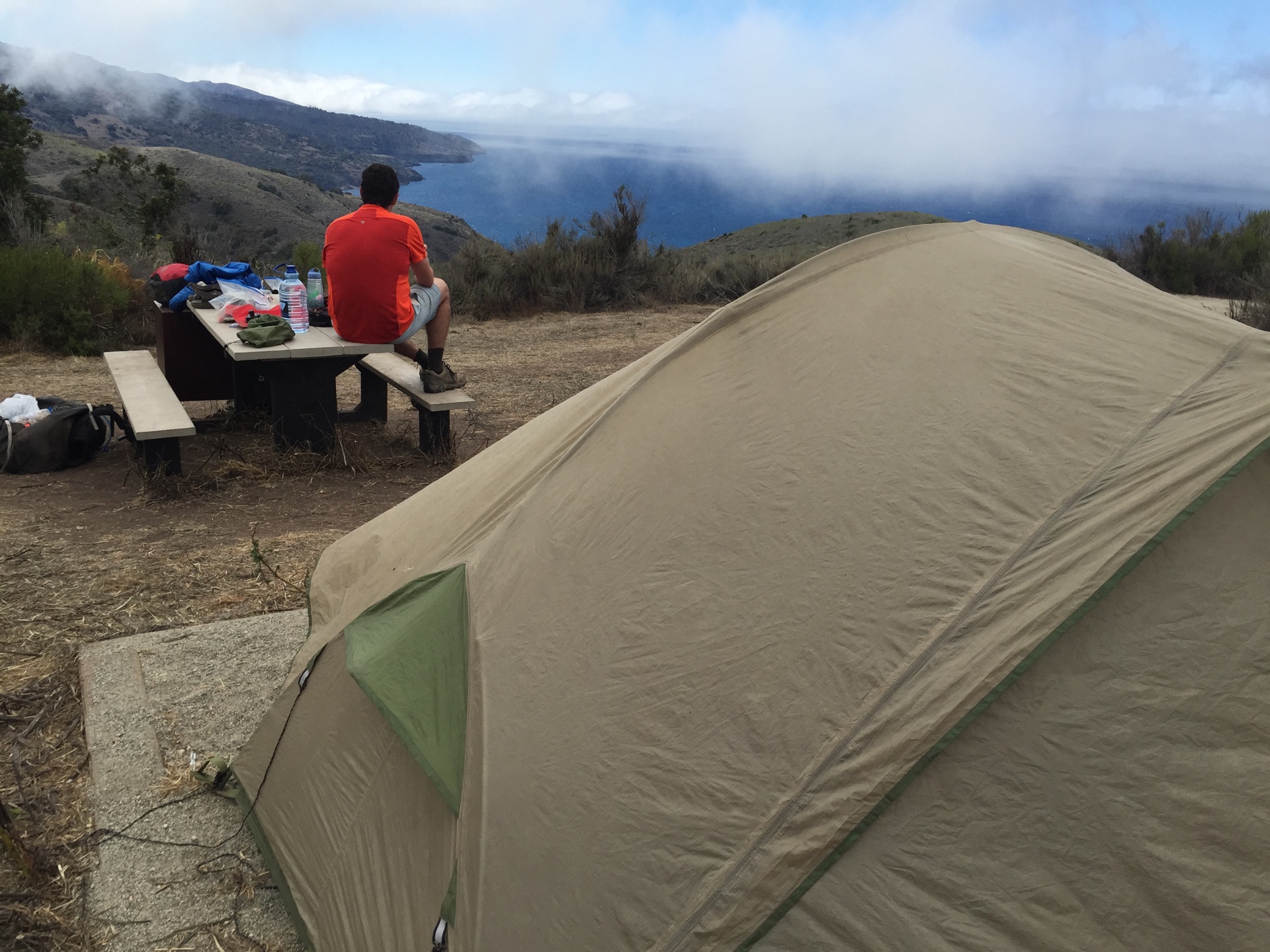 A camper enjoys the view from Del Norte Campground above Prisoner's Harbor on Santa Cruz Island, California.