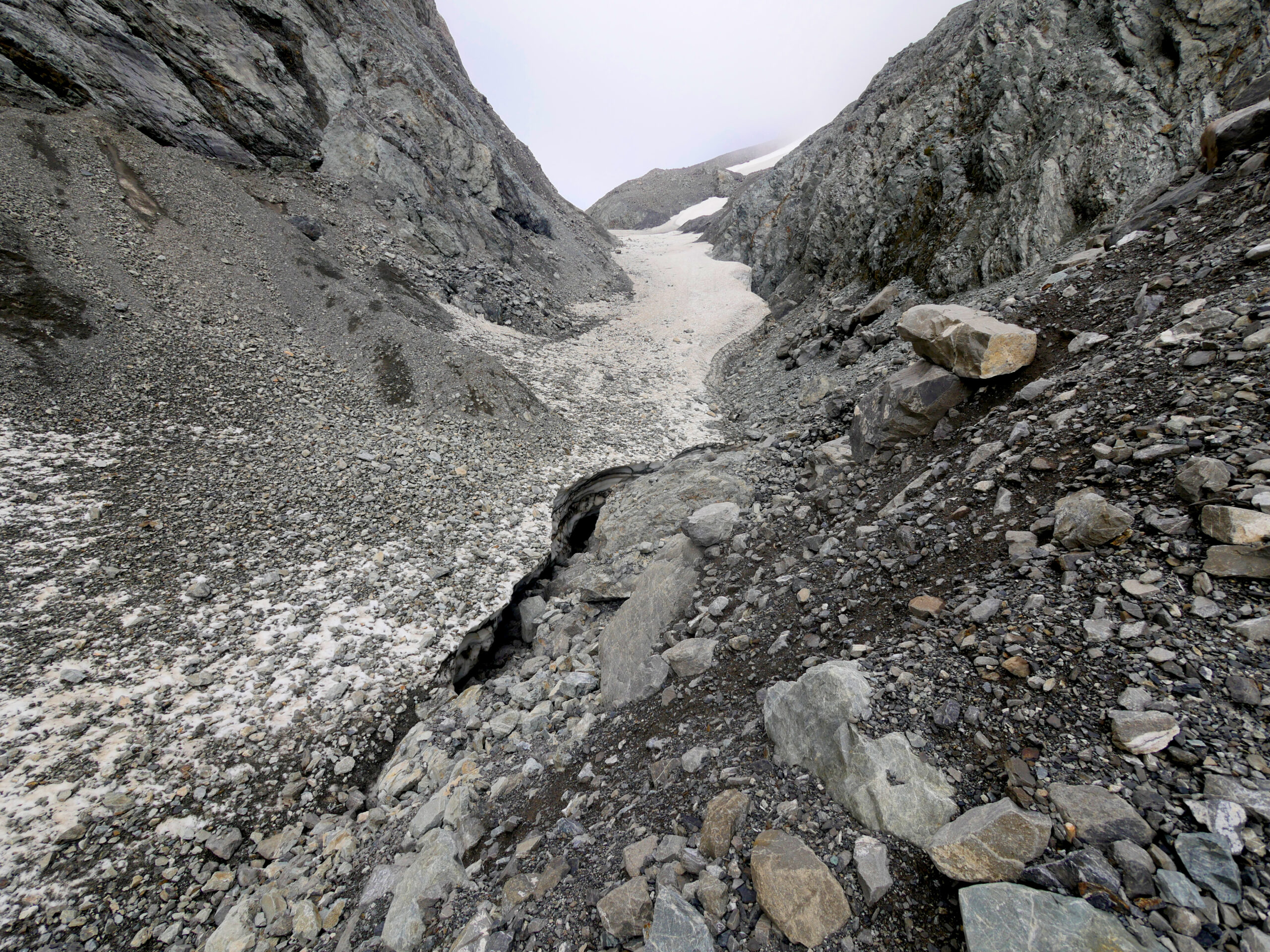 The route up Whitehorn Pass is covered in snow and ice fields. Crevasses below the melting snow are clearly visible.